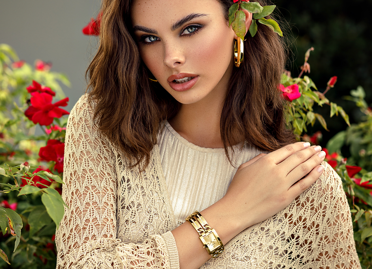 woman wearing gold watch with flower in her hair