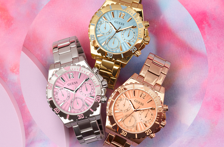 silver, gold and rose gold watches with colored dials on colored pink background