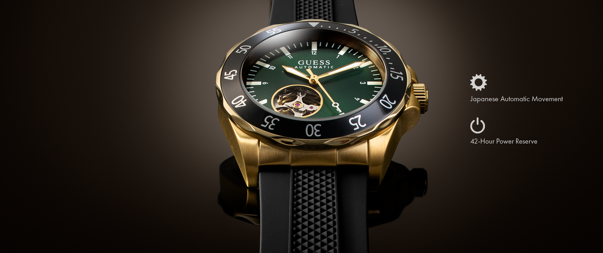A Guess wristwatch with a gold-tone case, dark green dial, black bezel, and black textured strap, shown on a dark gradient background with feature callouts on the right.