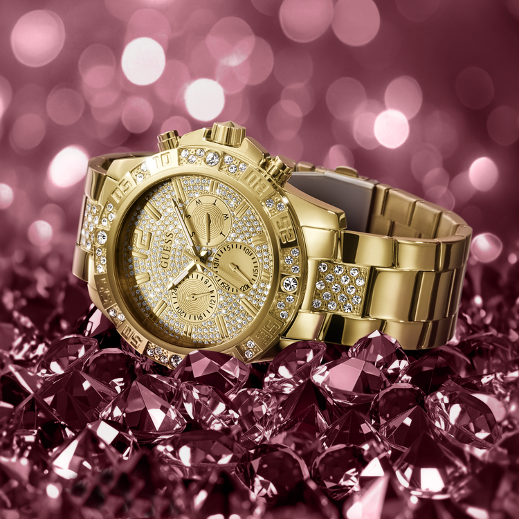 Gold watch with diamond accents on a pink gemstone background