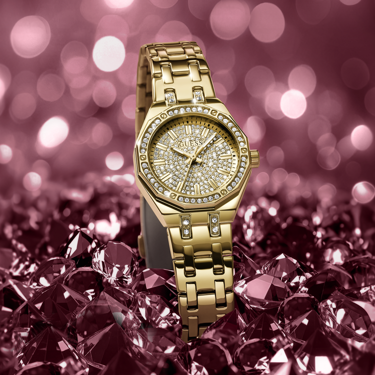 Gold watch with crytsal accents on a pink gemstone background