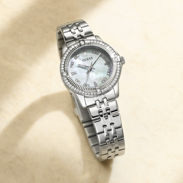 Silver Guess watch with a detailed MOP face on a beige background