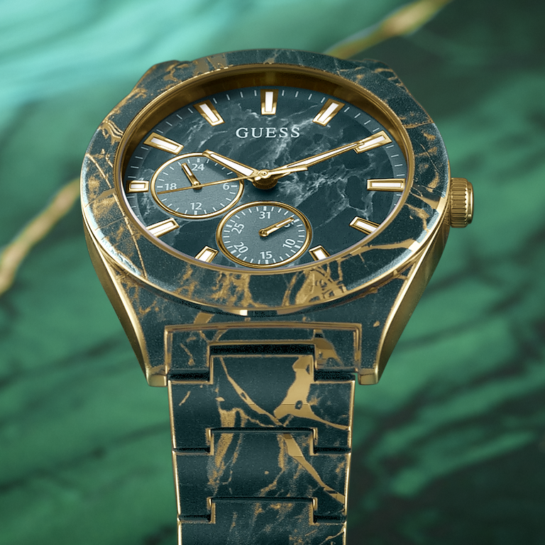 Marble-patterned watch with gold accents on a green background