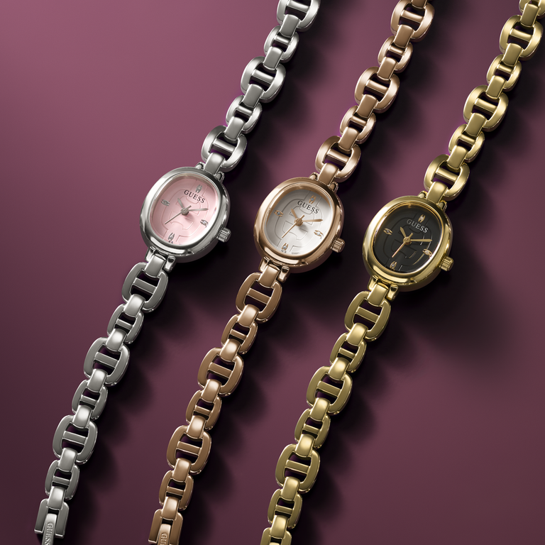 Three Guess watches in silver, rose gold, and gold on a purple background