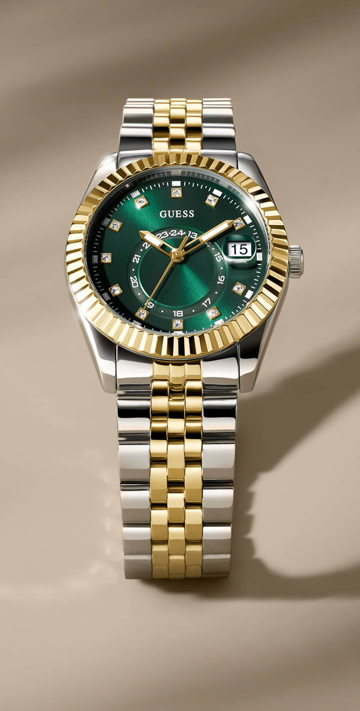Two-tone silver and gold watch with a green face on a beige background