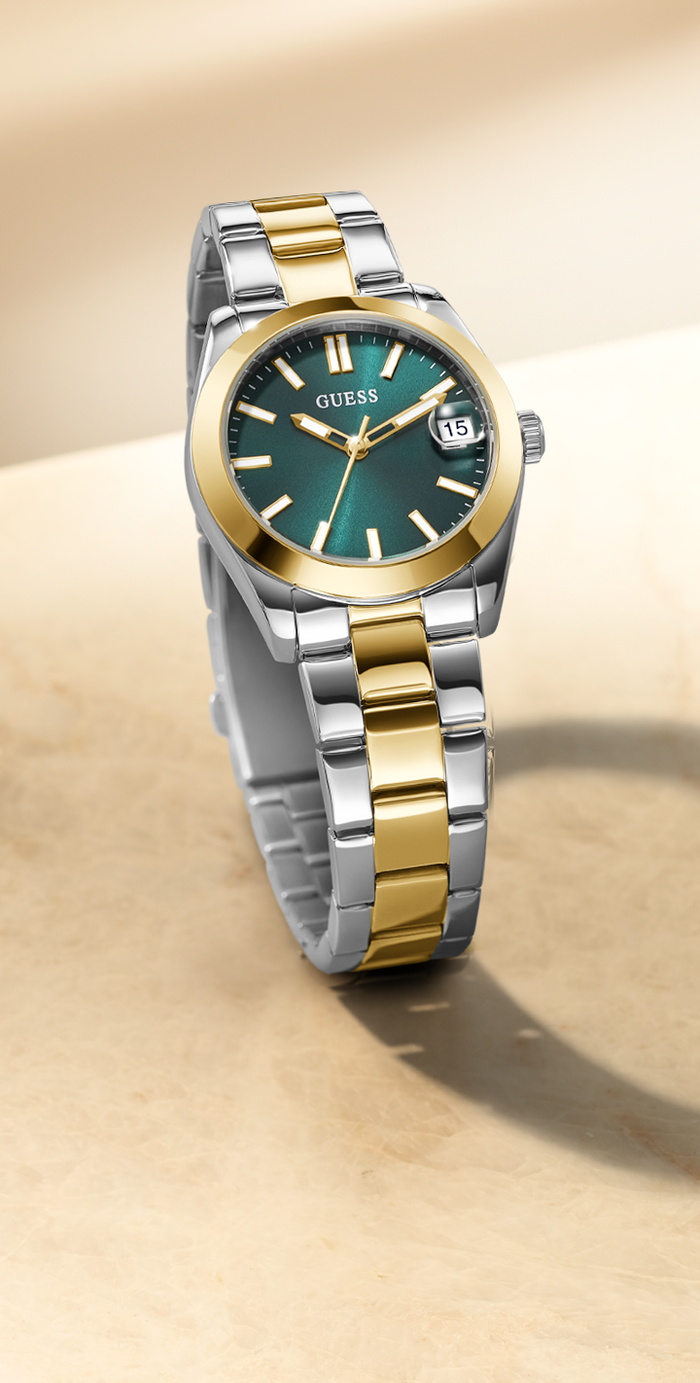 Two-tone watch with green face on a beige background