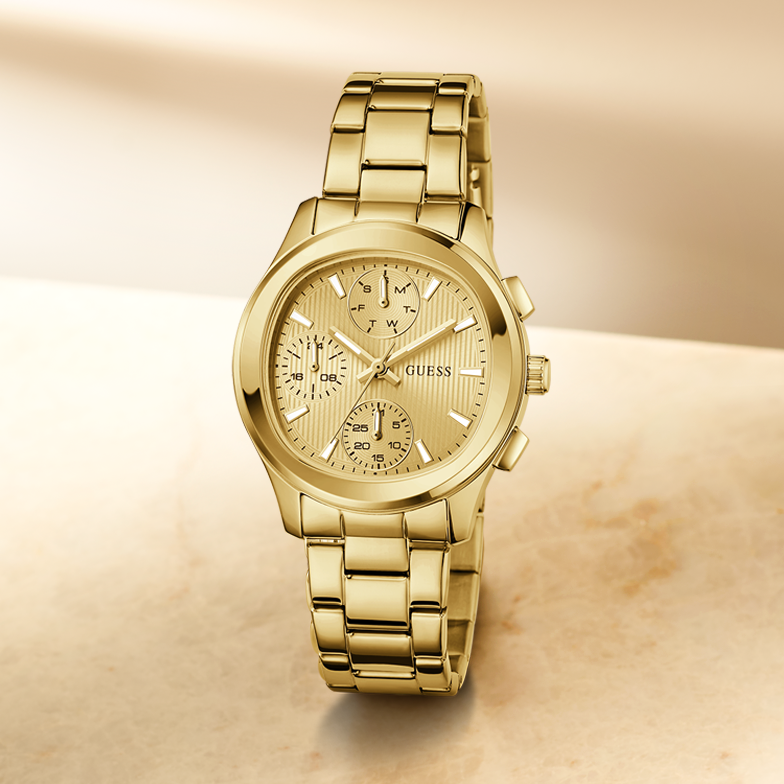 Gold watch with a detailed face on a beige background