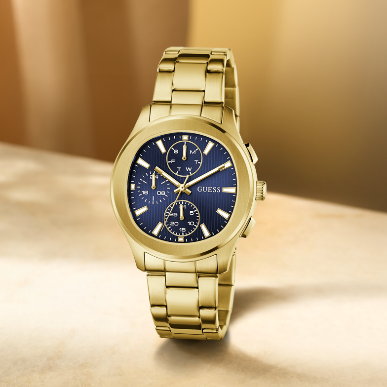 Gold watch with a blue face on a beige background