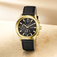 Gold watch with black strap on a beige background