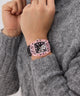 GUESS Mens Sporting Pink Multi-function Watch on a person's wrist with a gray sweater