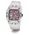 A Guess wristwatch with a transparent clear resin case, a pink skeleton dial, and a white silicone strap with pink stitching, shown on a white background.