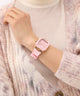 GUESS Ladies Sparkling Pink Rose Gold Tone Multi-function Watch on a wrist with a soft pink sweater