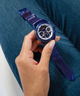 GUESS Eco-Friendly Blue Bio-Based Multi-function Watch lifestyle hand holding watch on leg