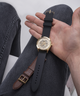 GW0449G1 GUESS Mens Gold Tone Multi-function Watch Box Set lifestyle hand holding watch and extra strap