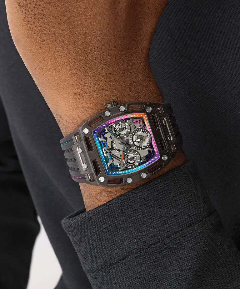 GUESS Mens Black Multifunction Watch with a unique design on a person's wrist against a dark background