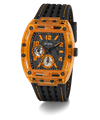 A GUESS men's watch featuring a transparent orange case and a black textured strap with orange stitching, set against a plain white background.