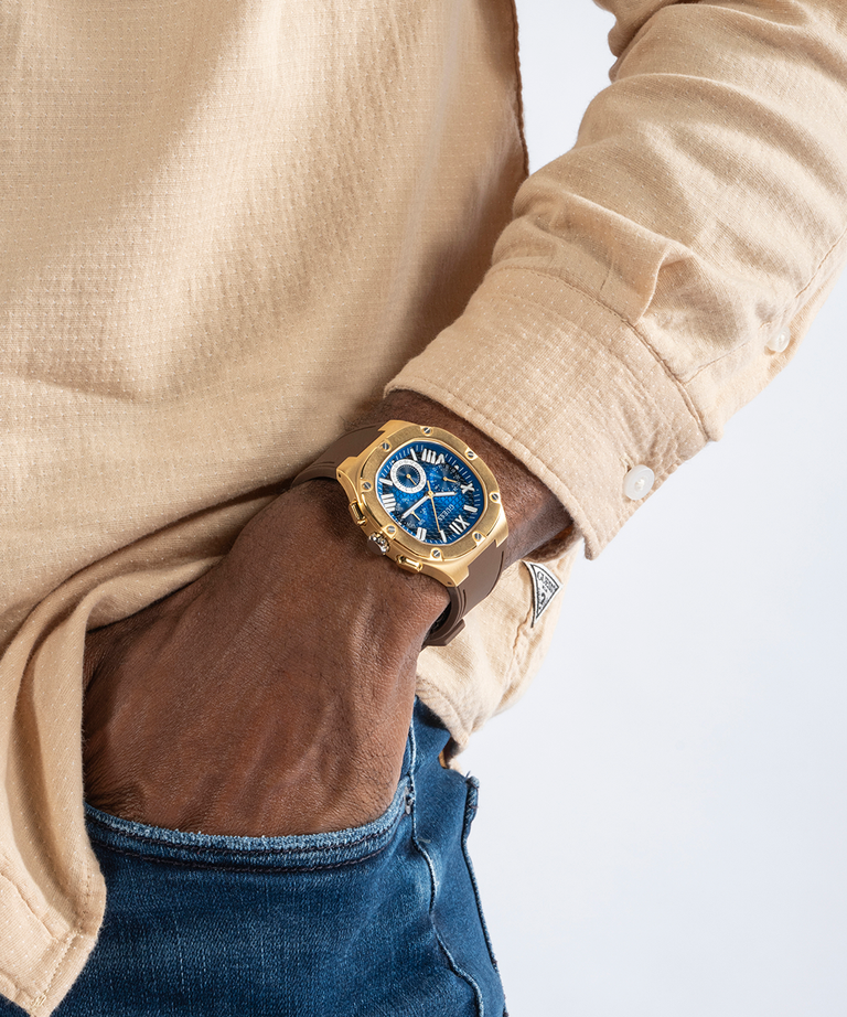 GUESS Mens Brown Gold Tone Multi-function Watch lifestyle watch on wrist and hand in pocket