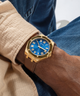GUESS Mens Brown Gold Tone Analog Watch lifestyle blue dialwatch on wrist