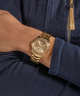 GUESS Ladies Gold Tone Multi-function Watch lifestyle watch on arm denim jacket