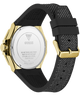 Back view of a Guess watch with a gold-tone stainless steel case and a textured black silicone strap, on a white background.
