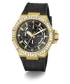 A gold-tone GUESS chronograph watch with a black textured strap, featuring a bezel set with clear crystals and a black dial with gold hands and subdials.