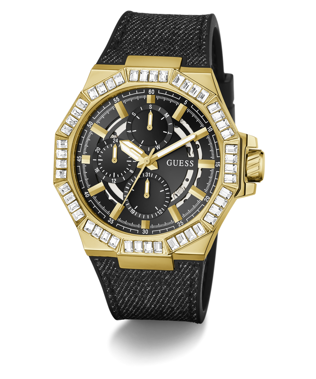 A gold-tone GUESS chronograph watch with a black textured strap, featuring a bezel set with clear crystals and a black dial with gold hands and subdials.