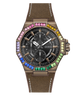 A GUESS wristwatch with a bronze-toned case, a black dial with three subdials, and a brown textured strap. The bezel is decorated with colorful rhinestones in blue, green, yellow, pink, and orange.