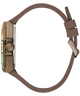 A side profile view of a luxury watch featuring a matte brown silicone strap, a bronze-toned case, and a bezel accented with green and yellow diamonds.