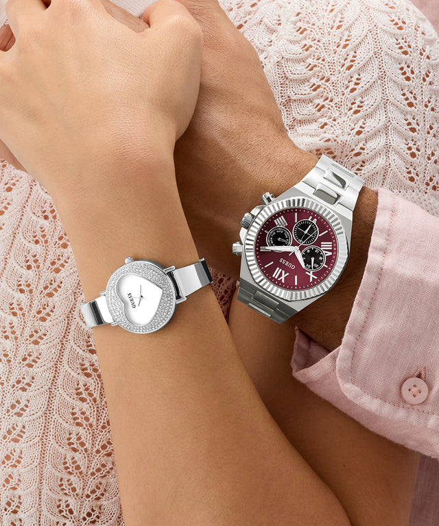 Two silver watches on a couples wrist with a lace background