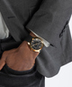 GW0728G2 GUESS Mens Black Gold Tone Analog Watch lifestyle hand in pocket