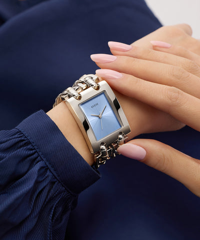 GUESS Mod Heavy Metal Ladies Silver Tone Analog Watch on a wrist with a blurred background