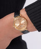 GW0764L2 GUESS Ladies Black Gold Tone Analog Watch watch on wrist