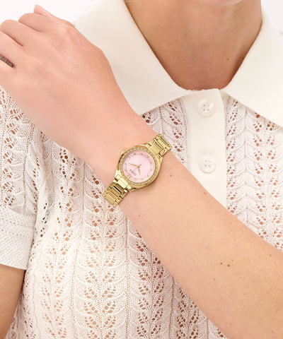 GUESS Ladies Gold Tone Analog Watch on a wrist with a white lace top