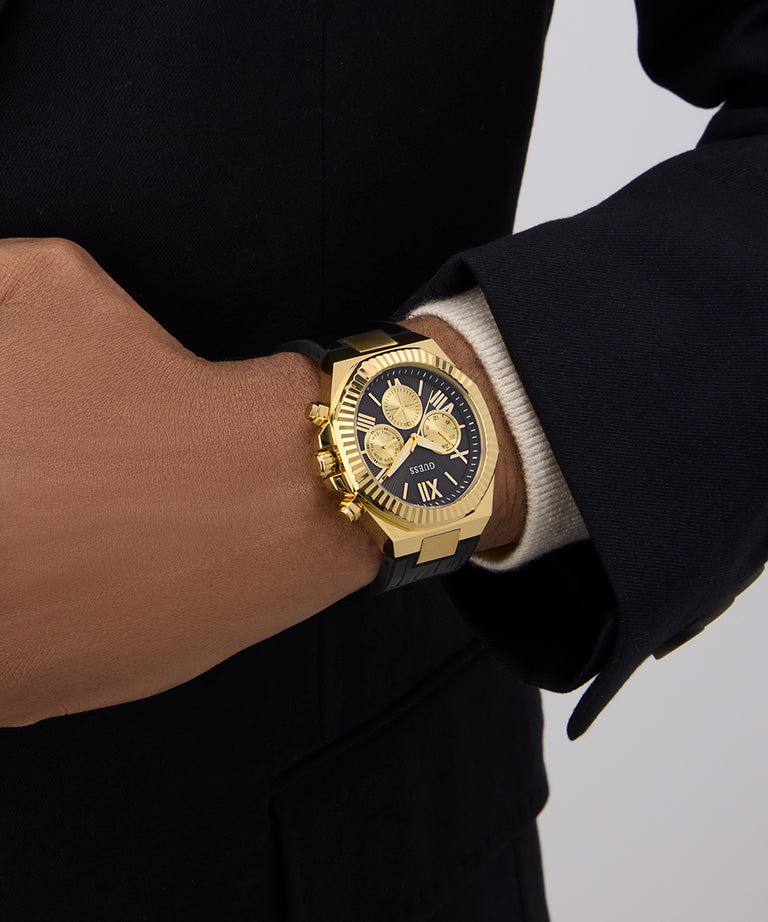 GUESS Mens Black Gold Tone Multi-function Watch on a wrist with a neutral background