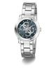 A Guess women's analog watch with a silver stainless steel link bracelet, a round bezel set with clear crystals, and a dark blue dial featuring the brand's interlocking G logo.