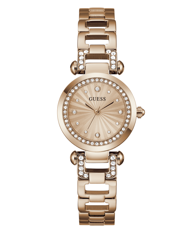A GUESS women's watch featuring a rose gold-tone metal case and link bracelet, embellished with clear crystals around the bezel and bracelet links. The dial is a matching rose gold color with a sunburst pattern and crystal hour markers.