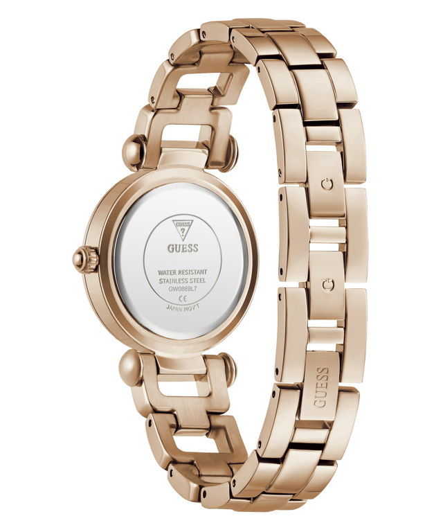 Rose gold stainless steel women's watch shown from the back, featuring a matching link bracelet and a round case with a clear back cover displaying the GUESS brand name.