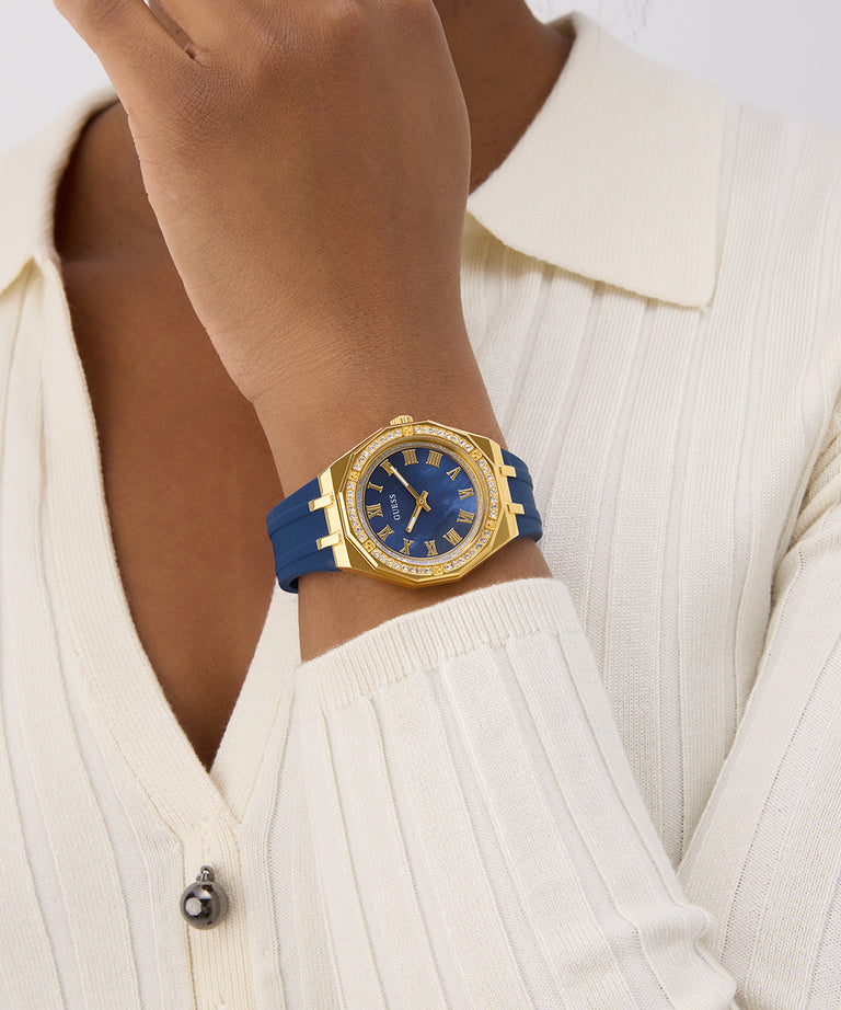 Gold watch with blue strap worn by a person in a white outfit GW0872L4