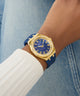 Gold and blue watch on a wrist with denim background GW0872L4