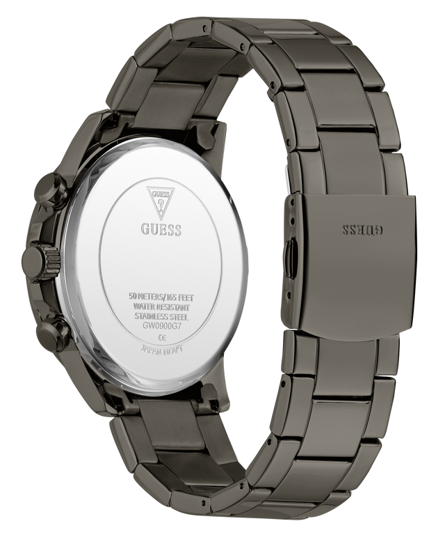 A close-up studio shot of a GUESS watch showing the back of the case and the metal link band. The watch has a dark gunmetal gray stainless steel case and band, with a polished silver-toned circular back plate.