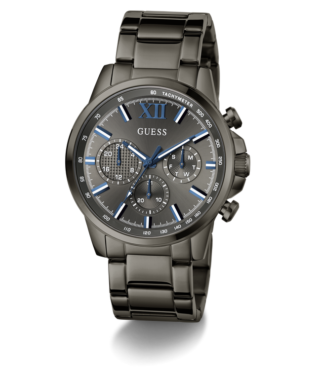 A GUESS men's chronograph watch with a dark gunmetal gray stainless steel case and integrated link bracelet, featuring a matching gray dial with blue accents, Roman numeral XII, and three subdials.
