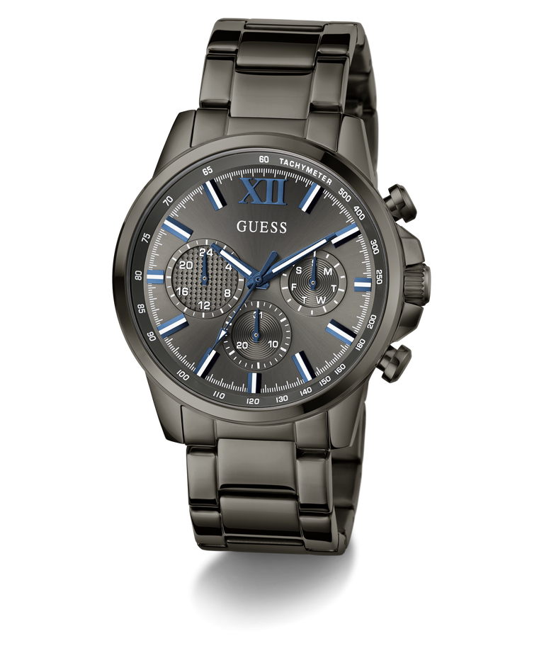 A GUESS men's chronograph watch with a dark gunmetal gray stainless steel case and integrated link bracelet, featuring a matching gray dial with blue accents, Roman numeral XII, and three subdials.