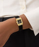GUESS Ladies Black Gold Tone Analog Watch on model's wrist