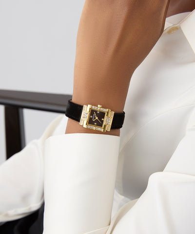 womans wrist wearing GUESS Ladies Black Gold Tone Analog Watch