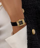 wrist wearing GUESS Ladies Black Gold Tone Analog Watch
