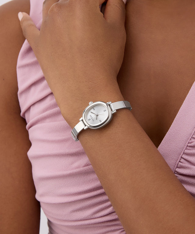 Silver watch on a wrist with a pink sleeve