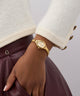 Gold watch on a wrist with a neutral background GW0924L2