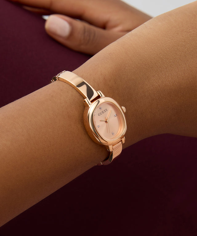 GUESS Ladies Rose Gold Tone Analog Watch on a wrist with a blurred background