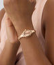 GUESS Ladies Rose Gold Tone Analog Watch on a wrist with a soft pink background