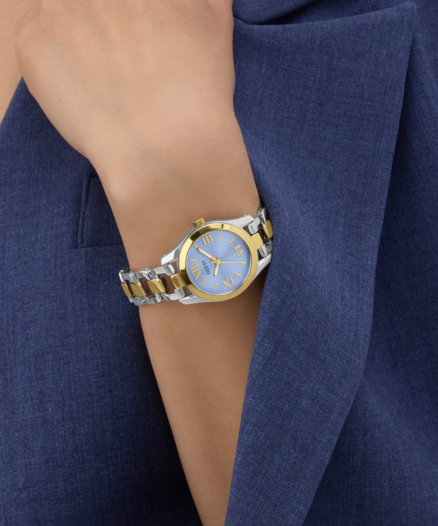 GUESS Ladies 2-Tone Analog Watch on a wrist with a blue jacket